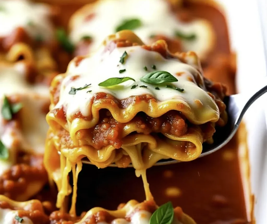 Lasagna roll ups with cottage cheese baked in dish, topped with melted mozzarella and fresh basil