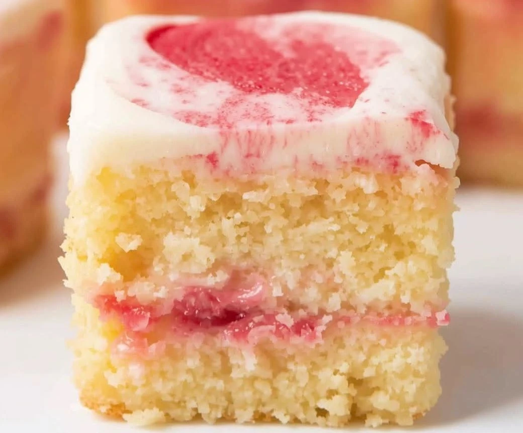 Bright Lemon Raspberry Swirl Square Cupcakes topped with yellow lemon buttercream and a fresh red raspberry.